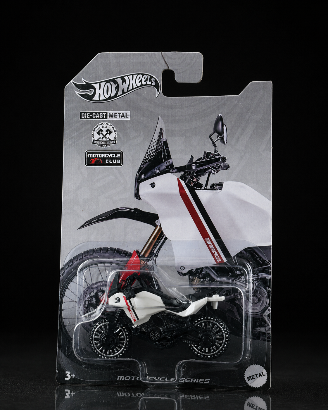 Die-cast rally adventure motorcycle on dark studio background