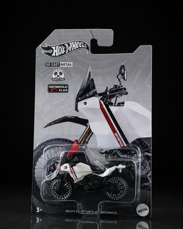 Die-cast rally adventure motorcycle on dark studio background