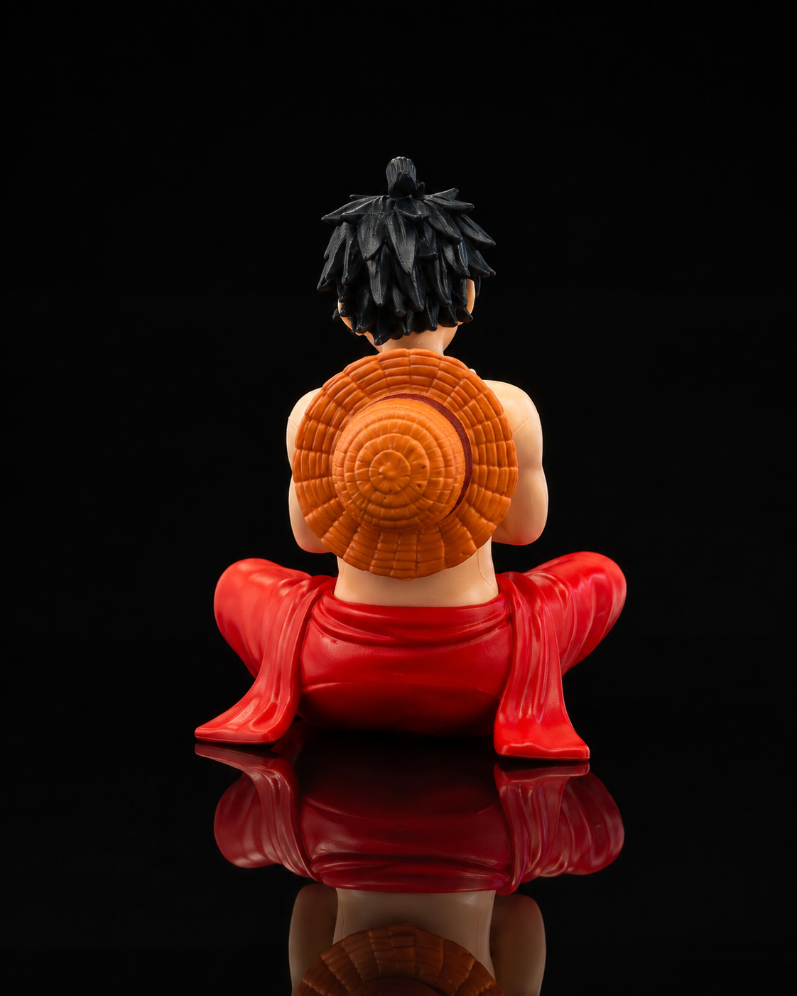 Luffy sitting anime figure, back view showing straw hat