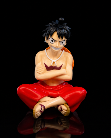 Luffy sitting anime figure on dark studio background